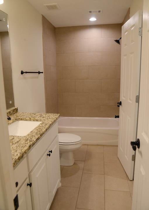 A bathroom with a toilet, sink, and bathtub.