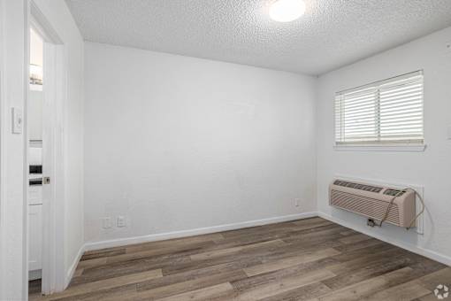 A room with a window and a wall-mounted air conditioner.