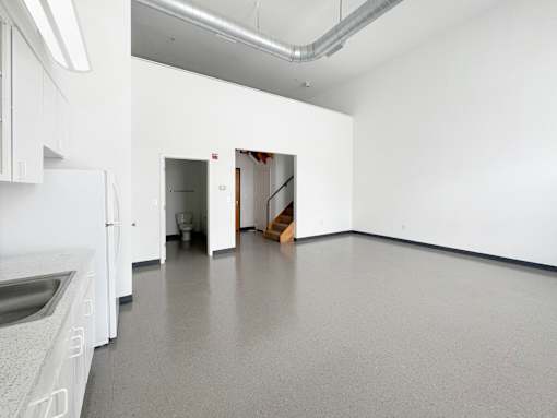 A kitchen with white cabinets and a white fridge.