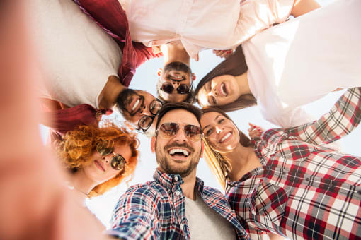 a group of people standing in a circle with their heads together