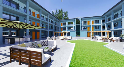 a grassy courtyard with a couch and chairs in front of a building