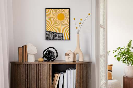 A shelf with books, a sculpture, and a vase with flowers.