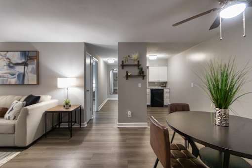 A modern living room with a white couch, a coffee table, and a painting on the wall in a 1 bedroom, 1 bath 560 square foot apartment at Aspen Village Apartments in the Westwood neighborhood of Cincinnati, OH.