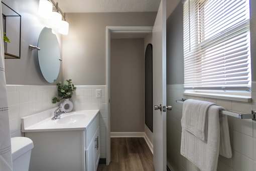 A bathroom with a white sink and a white toilet in a 1 bedroom, 1 bath 560 square foot apartment at Aspen Village Apartments in the Westwood neighborhood of Cincinnati, OH.