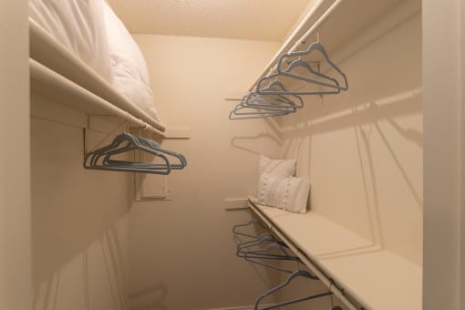 This is a photo of the bedroom walk-in closet in a 692 square foot 1 bed, 1 bath model aprtment at Cambridge Court Apartments in Dallas Texas