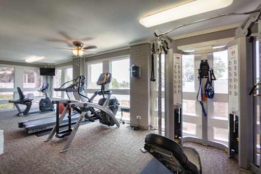 The fitness center with rowing machine, elliptical, treadmill, bike, weight system and free weights at Cambridge Court Apartments in Lake Highlands, Dallas, TX.