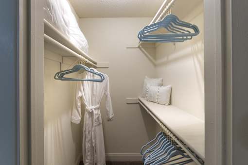 Walk-in closet in a 1-bedroom apartment at Cambridge Court Apartments in Dallas, Texas, showing built-in shelving and hanging space.