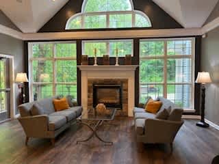 A living room with a fireplace and two chairs.