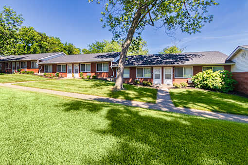 Single-story brick apartment homes with private entrances and open green lawn