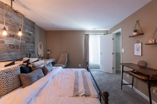 This is a photo of the bedroom with barb wood wall in the upgraded 650 square foot, 1 bedroom, 1 bath model apartment at Deer Hill Apartments in Cincinnati, Ohio.