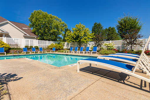 A pool with a white fence and blue loungers at Fairfield Pointe Apartments in Fairfield, Ohio.