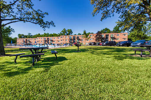 Community lawn with picnic tables, bbq grill and apartment buildings at Lisa Ridge Apartments on the west side of Cincinnati
