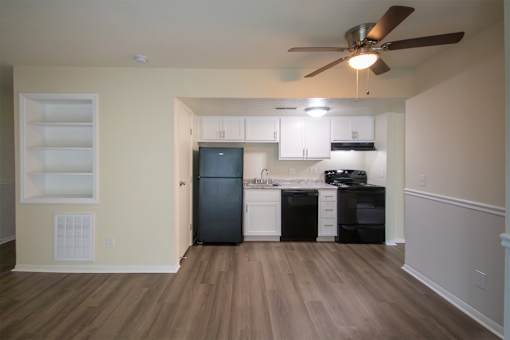 This is a photo of the kitchen and living room with built-in bookshelf of the 560 square foot 1 bedroom, 1 bath Elm floor plan at Montana Valley Apartments in Cincinnati, OH.