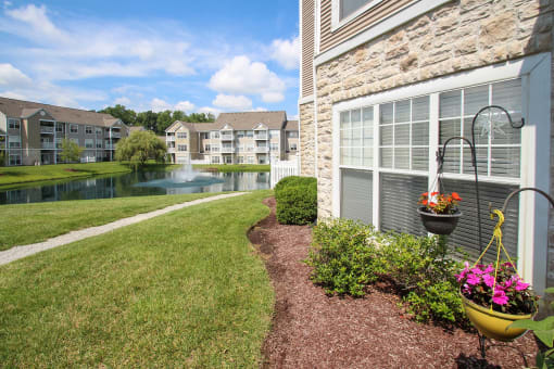This is a picture of a pond with a fountain and  building exteriors at Nantucket Apartments, in Loveland, OH.