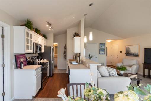 This is a photo of the kitchen and living room from the dining area in the 1016 square foot, 2 bedroom, 2 bath Nautica floor plan at Nantucket Apartments in Loveland, OH.