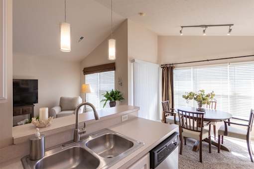 This is a photo of the living room and dining area from the kitchen in the 1016 square foot, 2 bedroom, 2 bath Nautica floor plan at Nantucket Apartments in Loveland, OH.