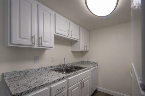 A kitchen with a white cabinets 1 bedroom, 1 bath apartment home at Princeton Court Apartments in the Vickery Midtown neighborhood of Dallas, TX.