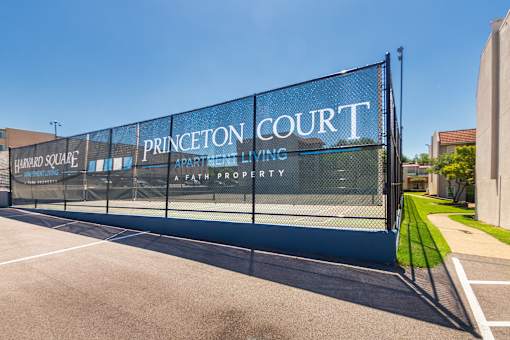 Mesh banner on fencing with Princeton Court and Harvard Square logos next to recreation area at Princeton Court Apartments in the Vickery Midtown neighborhood of Dallas, TX.