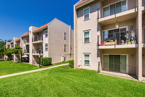 Apartment building with green space at Princeton Court Apartments in the Vickery Midtown neighborhood of Dallas, TX.