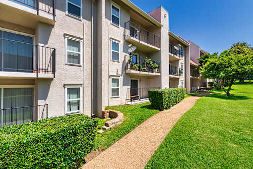 Apartment building with a green lawn in front.