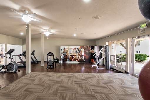24-hour fitness center with a variety of equipment including treadmills, weights, and exercise balls at Princeton Court Apartments in the Vickery Midtown neighborhood of Dallas, TX.
