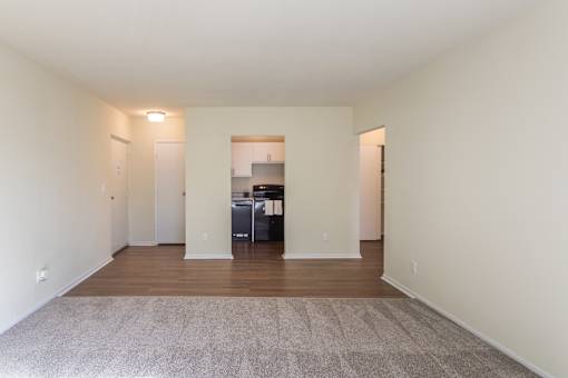 A spacious room with a kitchen in the background.