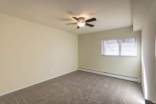A room with a ceiling fan and a window.