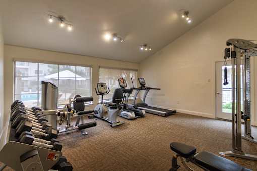 The 24-hour fitness center with treadmill, elliptical, free weights and other workout machines at The Summit at Midtown Apartments in Midtown, Dallas, TX.