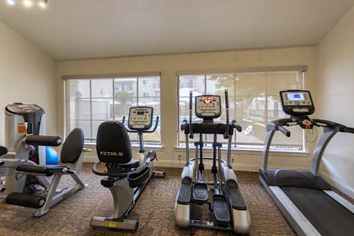 The 24-hour fitness center with treadmill, elliptical, free weights and other workout machines at The Summit at Midtown Apartments in Midtown, Dallas, TX.