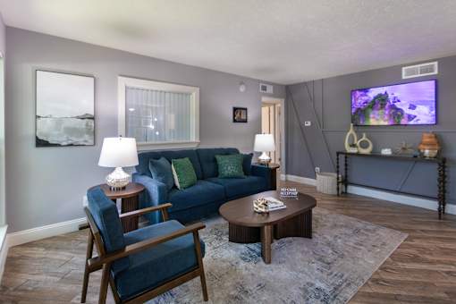 The leasing office with a blue couch and a television on the wall at The Summit at Midtown Apartments in Midtown, Dallas, TX.