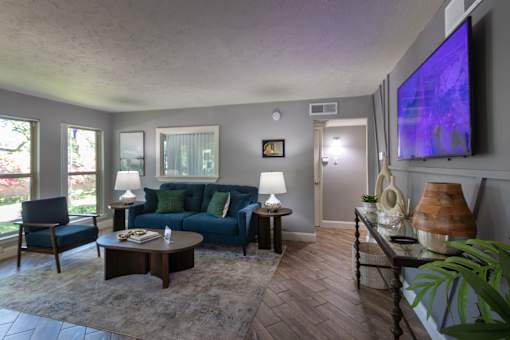 The leasing office with a blue couch and a television on the wall at The Summit at Midtown Apartments in Midtown, Dallas, TX.