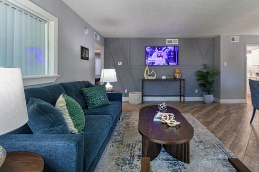 The leasing office with a blue couch and a television on the wall at Woodbridge Apartments in Midtown, Dallas, TX.