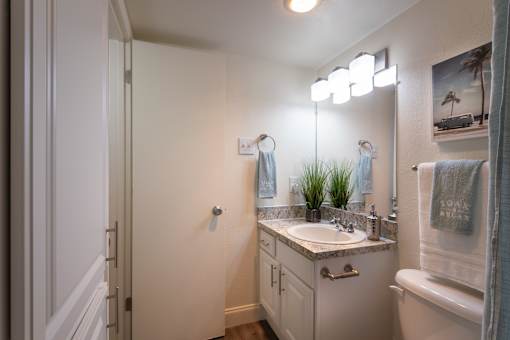 A bathroom with a white vanity in the 558 square foot 1 bedroom, 1 bath model apartment at The Summit at Midtown Apartments in the Dallas Midtown neighborhood of Dallas, TX.