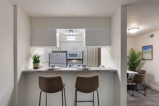 Breakfast bar with seating overlooking the kitchen and living area at The Summit at Midtown in Dallas, TX