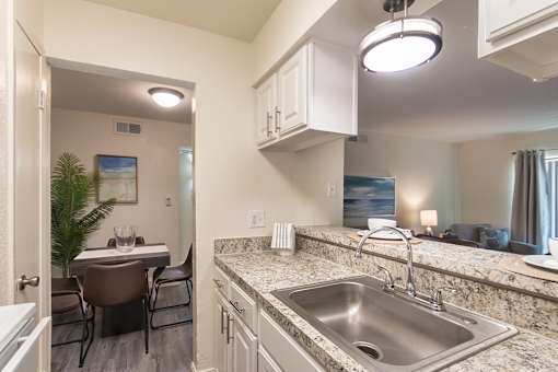 Kitchen pass-through and granite-style breakfast bar overlooking the dining and living area at The Summit at Midtown