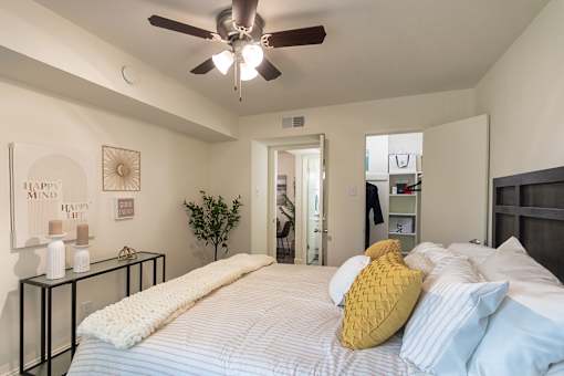 Bedroom with ceiling fan and access to the bathroom and closet area at The Summit at Midtown in Midtown Dallas