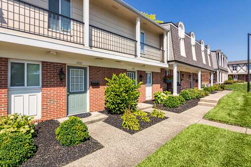 A row of townhouses with green doors and windows.