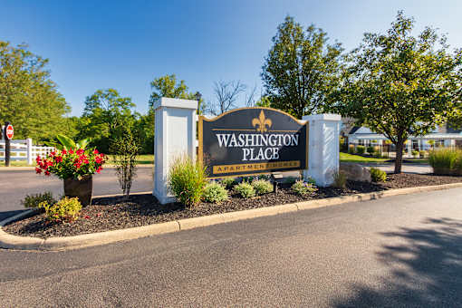 A sign for Washington Place Apartment Homes is shown in front of a building.