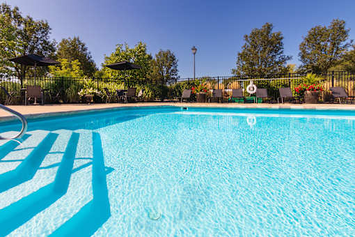 A swimming pool with sun loungers and umbrellas.
