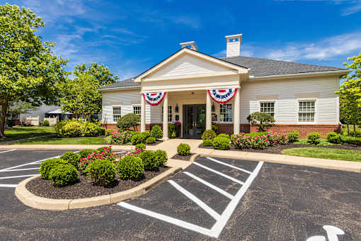 A building with a flag on the front and a parking lot in front of it.