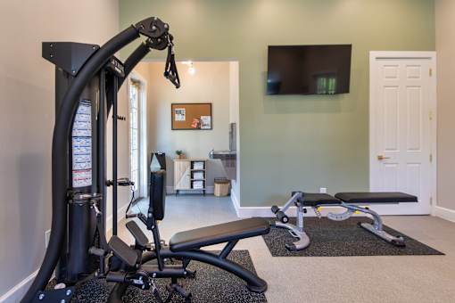 The 24-hour fitness center with universal machine and bench at Washington Park Apartments, in Centerville, OH.