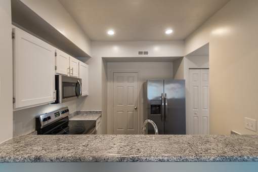 A kitchen with white cabinets and stainless steel appliances in the 1280 square foot, 2 bedroom, 2 and a half bath Oakwood floor plan  at Washington Park Apartments, in Centerville, OH.