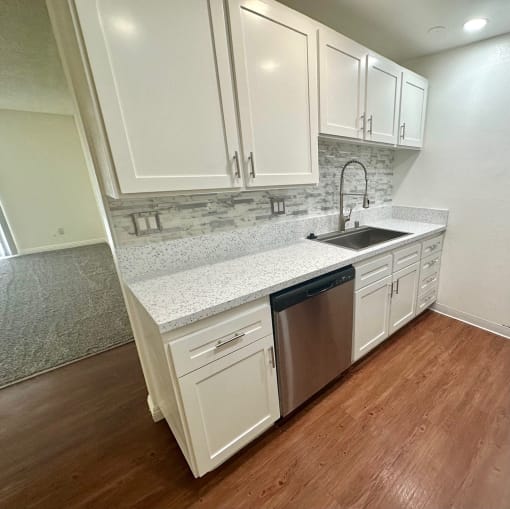a kitchen with white cabinets and a stainless steel dishwasher at Camino de Oro Apartments, Torrance, CA, 90505