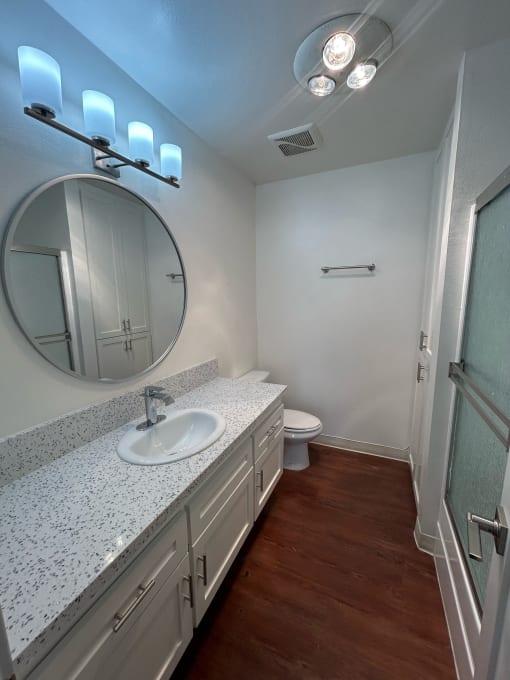 a bathroom with a sink and a toilet and a mirror at Copa Ladeene Apartments, Torrance California