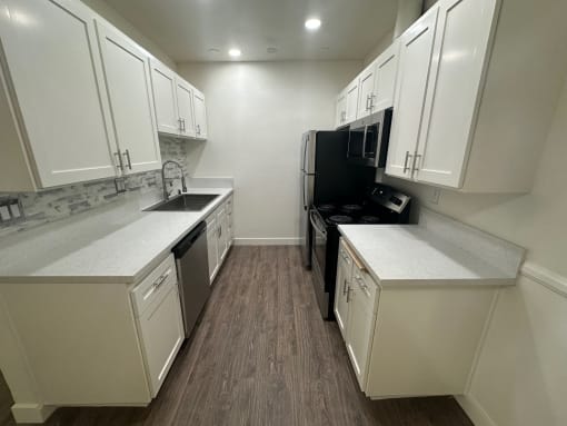 a kitchen with white cabinets and stainless steel appliances at Camino de Oro Apartments, Torrance, CA, 90505