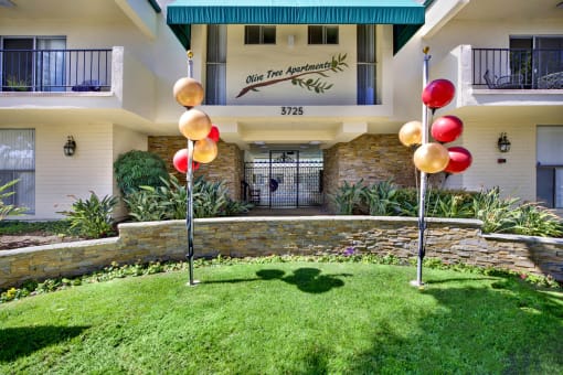 a yard with grass and balloons in front of a building at Olive Tree Apartments, Torrance, CA 90503