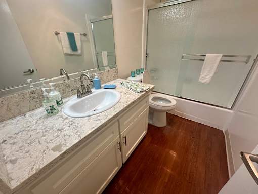 A bathroom with a marble countertop and a white sink.