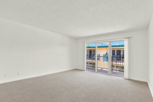 an empty living room with a door to a balcony at Camino de Oro Apartments, Torrance, CA, 90505