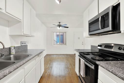 a kitchen with granite counter tops and black appliances at Casa Del Amo Apartments, Torrance, CA 90505