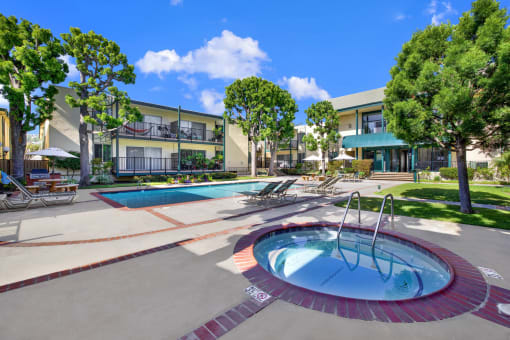 a jacuzzi and swimming pool in front of an apartment building at Copa Ladeene Apartments, Torrance California